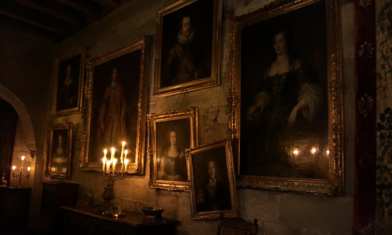 La galerie des ancêtres à la lueur des bougies, là où un cadre penche toujours un peu plus le soir.